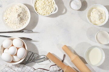 Frame for baking and making cake, bread, confectionery and ingredients for cooking, milk, flour, salt, sugar, eggs and cream on a concrete background with space for text, selective focus,