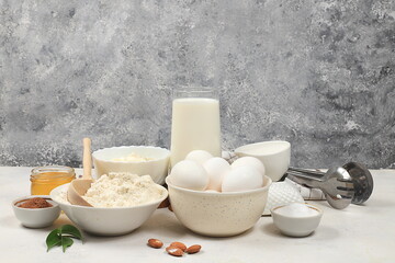Kitchen background for baking and making cake,bread,confectionery and ingredients for cooking,milk,honey,flour,salt,sugar,eggs and cream on concrete background