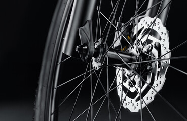 Disc brakes on a new bicycle close-up on a black background. Studio shot. Professional sport equipment. - obrazy, fototapety, plakaty
