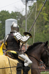 unknown knight in a suit of armor is riding on a horse and ready for battle