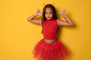Portrait of an angry little girl in a costume, on a yellow background. halloween.