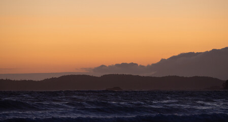 Waves on the Pacific Ocean on a rocky beach. West Coast. Sunny Summer Sunset.