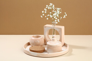 Concrete DIY pastel beige home decorations, vase with gypsophila flowers, podium in tray. Beauty product presentation concept.