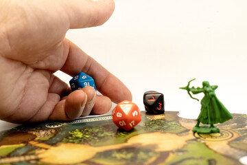 A hand throwing rpg dices on a adventure tile