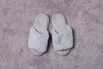 Fototapeta na wymiar Soft slippers on grey fluffy carpet, top view
