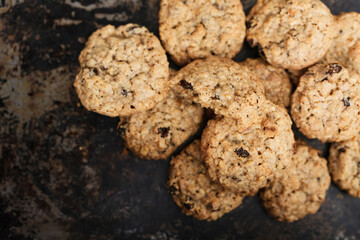 Müsli Oatmeal Cookies with raisins and dried fruits, most popular American biscuit on rustic, vintage baking sheet, selective focus macro shot of traditional home made rolled oats cookies from the USA - 531553055