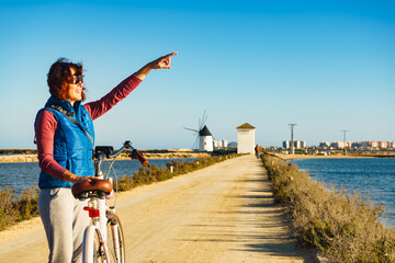 Woman with bike at San Pedro del Pinatar park, Spain - obrazy, fototapety, plakaty