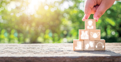 Work safety concept, Man hand holding wooden cube block with Work safety icon with copy space.