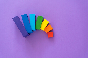 Multicolored abstract rainbow background. Wooden kids toys on violet paper. Educational toys...