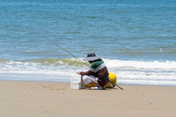 A fisherman puts bait on a hook to catch fish.