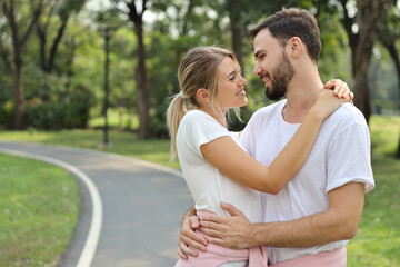 Fototapeta premium young couple caucasian people are in love. man and girl wearing white shirt hugging in the park during summer season with smiling and happy face
