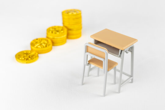 玩具の金貨と勉強机。金融教育のイメージ