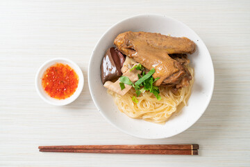 dried noodles with braised duck in white bowl