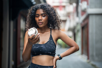 Fototapeta na wymiar African woman sport healthy fit and firm slim drink water from cup on the hand. athletic running wearing in the sportswear at city and town. Fitness and sport motivation. Runner concept.