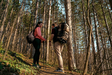 Young couple hiking together through the forest  