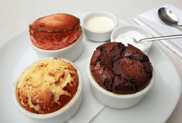 Chocolate, strawberry and coconut souffles on the dessert plate.