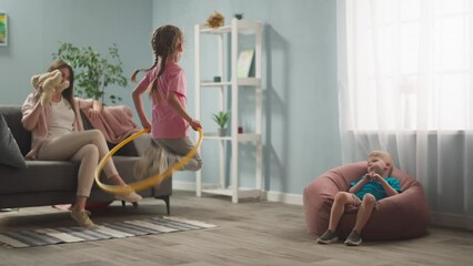 young woman, mother with children playing in room, throwing toys, twisting hoop, weekend with children, family - Powered by Adobe