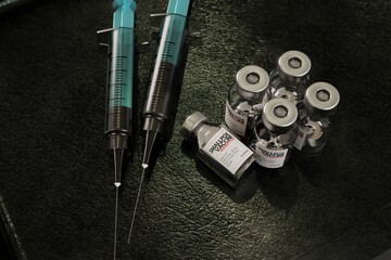 Monkeypox and smallpox vaccine ampoule, sided by a blue transparent syringe. Emergency stockpile trying to stop the 
 breakout. Emergency room environment.