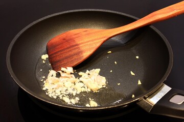Fry the garlic in a pan with with wooden spatula