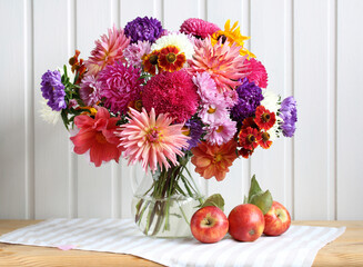 Autumn garden flowers in a glass vase on the table. Cottage core. Still life with a bouquet.