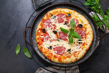 Freshly baked pepperoni pizza on dark background.