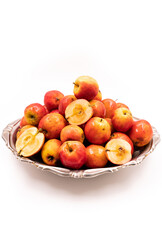 Ripe red small apples Ranetka on a metal plate, on a white background. Isolated background