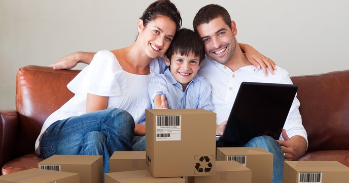 Caucasian couple and their son using laptop shopping online with a pile of boxes