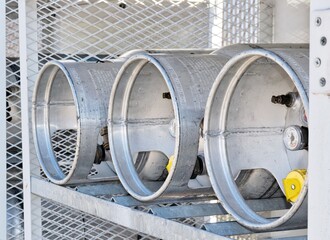 Three Liquid Petroleum gas cylinders stored horizontally in a metal safety cage, closeup eye level...