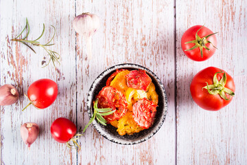 Dried tomatoes with spices and garlic in a bowl and fresh vegetables. Homemade snack. Top view