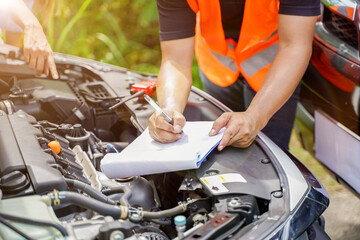 Closeup and crop auto repair checking engine and post a list of repairs according to customer...