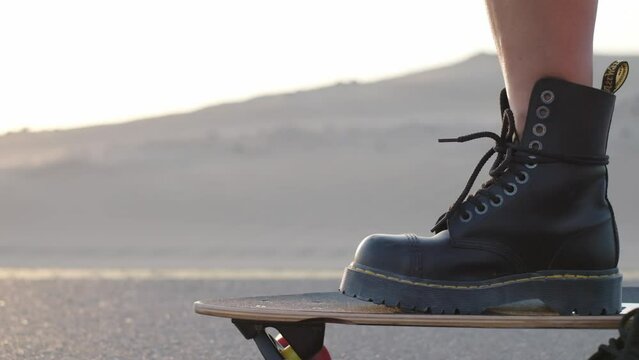 Girl rides on a skateboard on a desert road