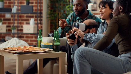 Multiethnic group of friends using vr headset to play video games online on television console. People having fun with gaming competition and virtual reality 3d glasses. Handheld shot.