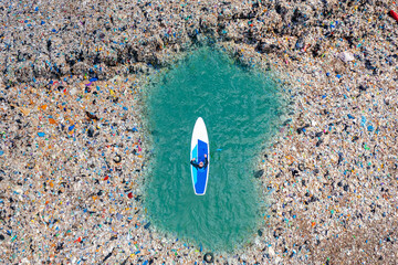 Aerial top view sup board paddleboard turquoise blue water sea. Concept pollution garbage plastic...