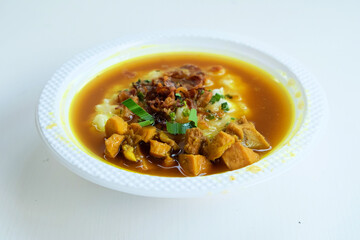 Delicious Indonesian food from chicken porridge served in a bowl with traditional side dishes on a white background
