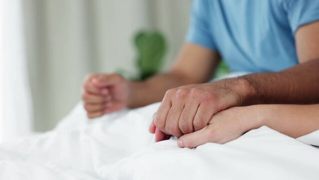 Infertility, support, and couple holding hands while in bed together, loving and showing empathy. Erectile dysfunction, depression, and marriage conflict by man and woman discussing forgiveness