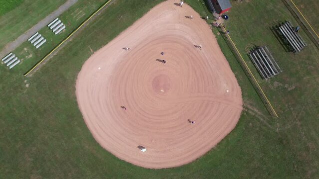 Top down aerial view softball field or diamond with people playing sport