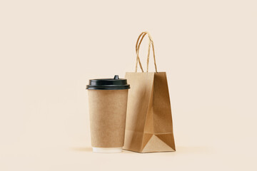 Takeaway paper coffee cup with lunch bag on beige. Snack delivery service. Coffee to go. Grab and...