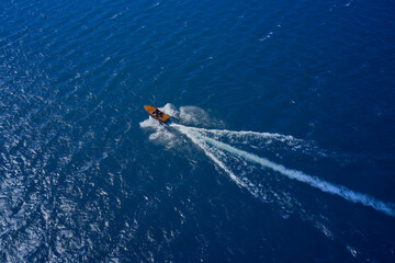 Obraz premium Speed boat at sea, view from above. Vintage wooden boat in sea. Boat drone photo.