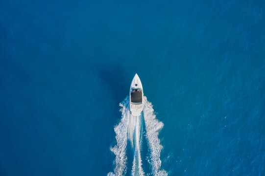 Aerial view luxury motor boat. Motor boat in the sea. Drone view of a boat sailing. Travel - image. Top view of a white boat sailing to the blue sea.