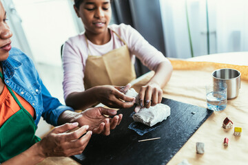 Mother and daughter spend time together and sculpting from clay at home