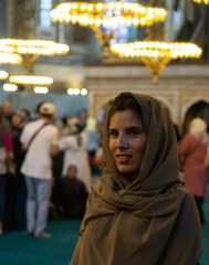 Young veiled female tourist visiting the interior of the Hagia Sophia mosque.