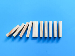 A row of wooden blocks against blue background. Concept of solution and domino effect.
