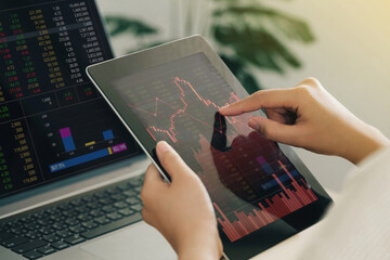 Businesswoman using a tablet computer analyzing stock exchange market crypto trading decreasing...
