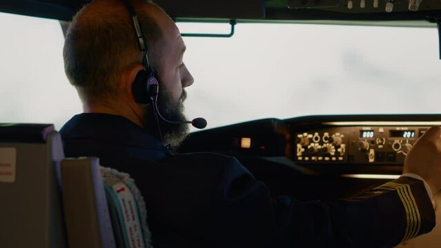 Airplane captain pushing buttons to fix altitude and longitude, flying plane from cockpit. Starting power engine on dashboard command and control panel, using aerial navigation.