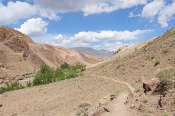 Picturesque place in the mountains. A trail for hiking on a sunny day. Beautiful photo wallpaper.