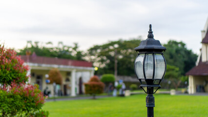 Black garden lights with bokeh green fields in the afternoon and the composition of copy space. Lamp post in the park. 