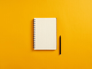 Blank or empty notepad and black pen on yellow background