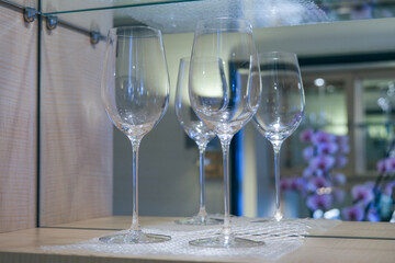 Wine glasses in shelf cupboard kitchenette inside suite stateroom cabin onboard luxury ocean...