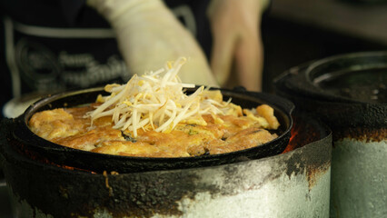Thai food, called Pad Thai, is being cooked on a rather black stove.