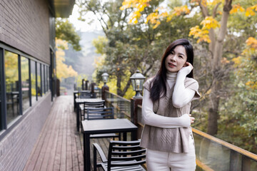 Sad tired Asian woman lonely at outdoor cafe during self isolation quarantine for COVID-19 Coronavirus social distancing prevention. Mental health, anxiety depressed thinking lady.